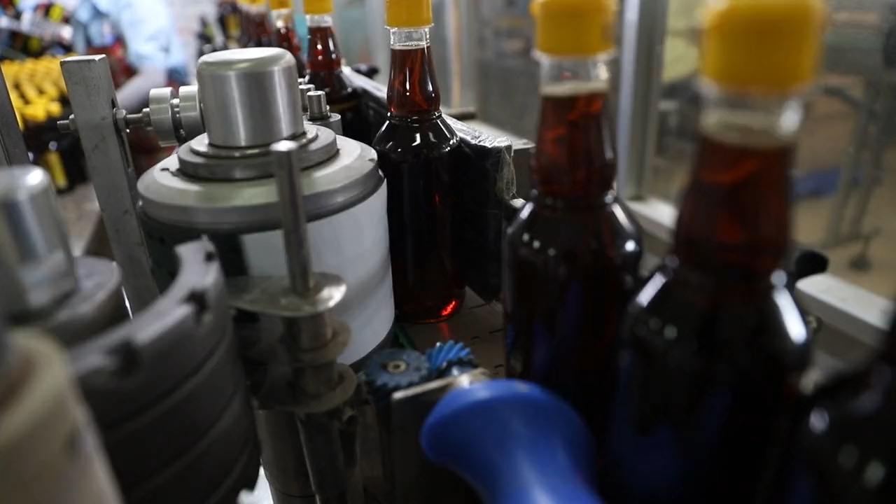 Imagen ilustrativa de botellas en una línea de embotellado